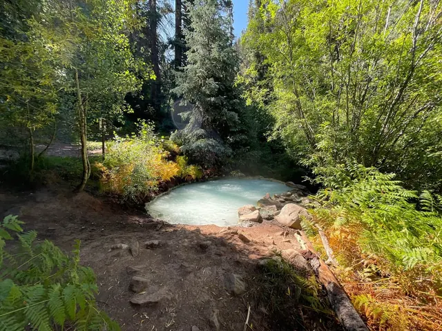  turquoise geothermal pool in a forest clearing in autumn at geyser warm spring colorado
