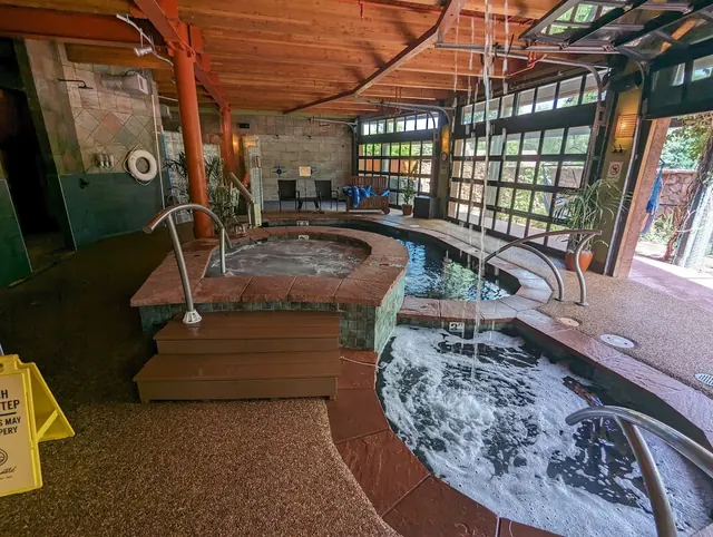 Indoor hot spring pool area at SunWater Spa Hot Springs in Manitou Springs, Colorado with bubbling water and visible steam.