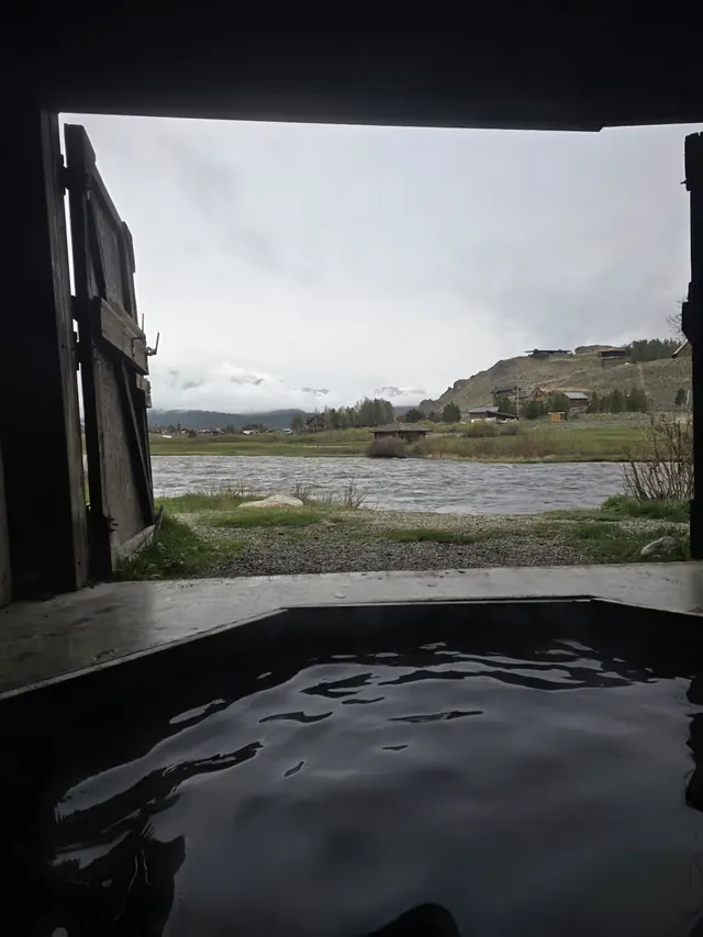 Steaming indoor hot spring pool overlooking the river and distant mountains at Mountain Village Resort Hot Springs near Stanley, Idaho
