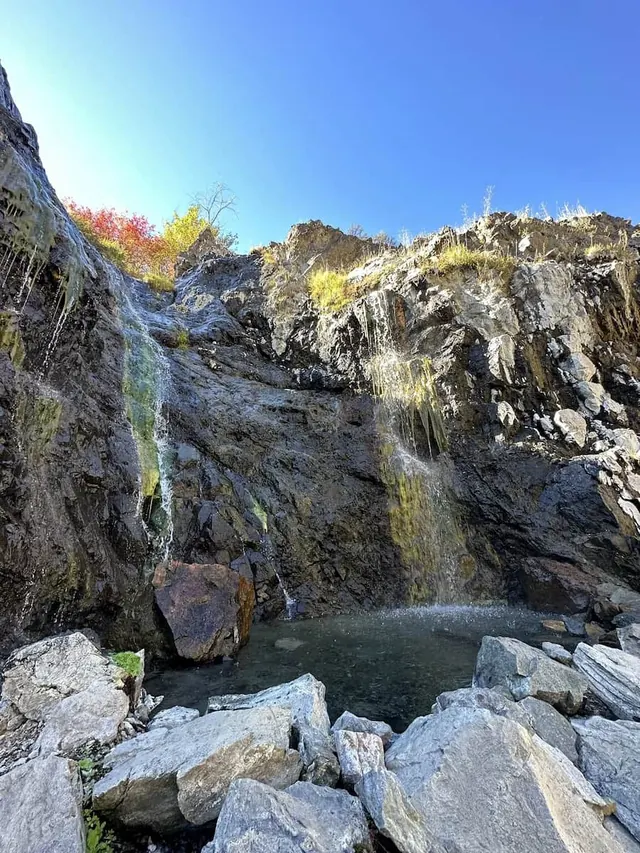hot springs pouring from cliff face into a natural hot spring pool at shower bath hot springs idaho 
