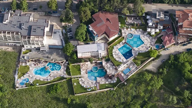 Aerial view of multiple connected outdoor spa pools and surrounding buildings at Aqua Club Kotvata in Sapareva Banya Bulgaria.