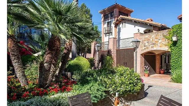 Garden area with lush greenery and palm trees near the entrance building of Roman Spa Hot Springs Resort located in Calistoga California.