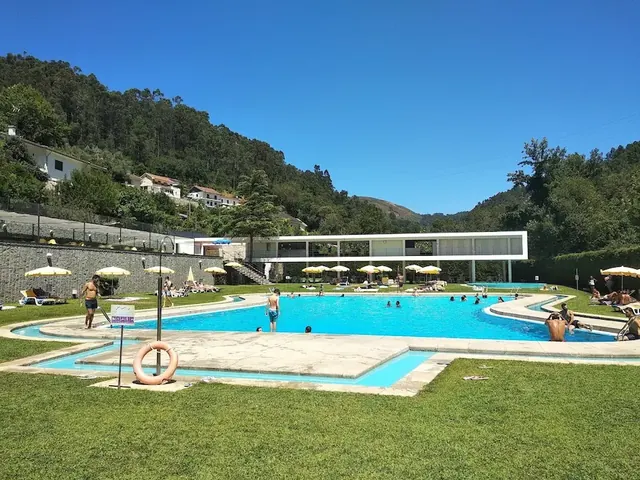 Outdoor hot spring pool in a thermal spa with forested hills in the background at termas de caldelas in portugal
