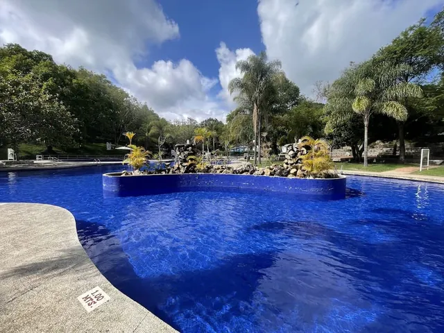 Outdoor hot spring pool surrounded by lush vegetation at parque aquatico ixtapan mexico