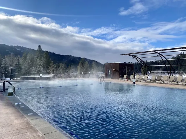 Steam gently rising from a large outdoor hot spring pool with mountainous forest backdrop at The Springs, Idaho City, Idaho.