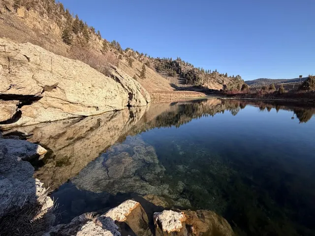 mirror lake with rugged terrain at nimrod hot springs montana