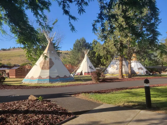 Tall teepees painted with Native designs set among trees and garden paths near Kah-Nee-Ta Hot Springs resort in Warm Springs Oregon on a su.