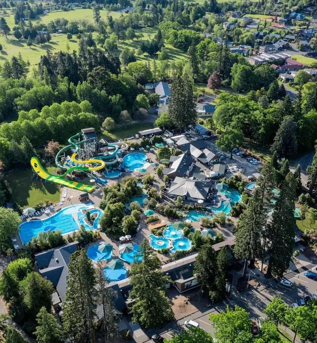 Aerial view of Hanmer Springs Thermal Pools & Spa with multiple pools water slides and surrounding green trees in Hanmer Springs New Zealan.