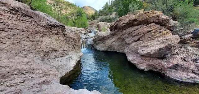 Natural hot spring pools surrounded by rocks and vegetation at turkey creek hot springs in new mexico