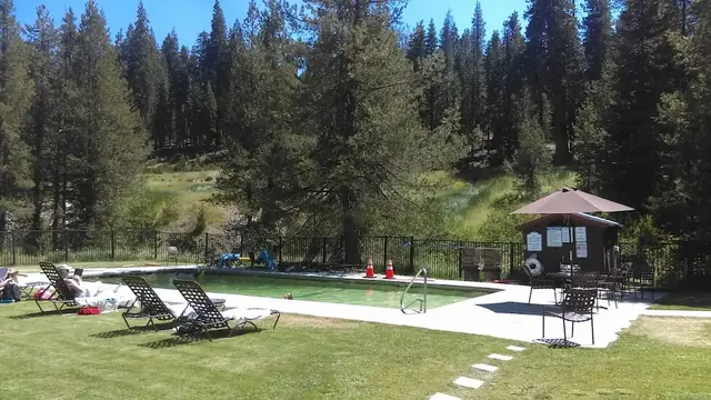 Outdoor hot spring pool with forest in the background in a resort setting at drakesbad guest ranch in california