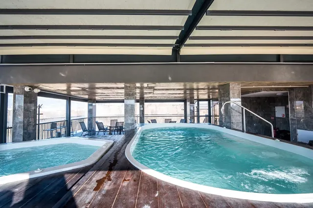 Two indoor spa pools with clear water in a room with large windows showing a distant view near Hotel Tsarska Banya, Banya, Bulgaria.