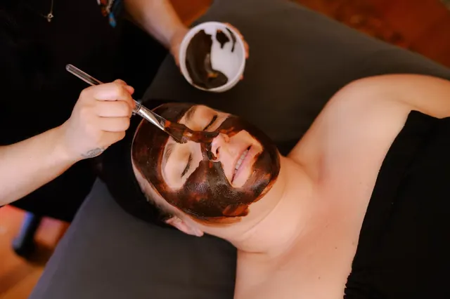 Person receiving a dark clay facial treatment inside at Steamboat Hot Springs Healing Center & Spa near Reno, Nevada for skin rejuvenation