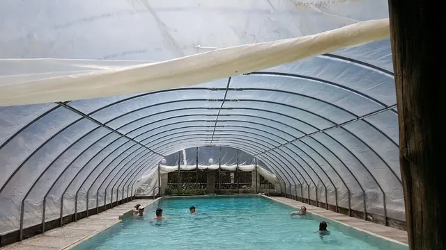 Children enjoying the covered mineral pool with a metal arch structure at Lost Trail Hot Springs located in Montana.