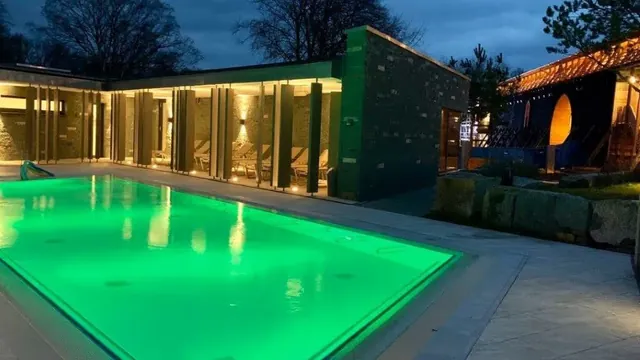 Large rectangular outdoor pool with blue water and lounge chairs on the side at Borde Therme Bad Sassendorf near Bad Sassendorf in Germany.