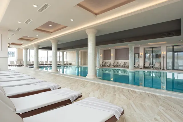 Large indoor mineral pool with blue water and white mosaic columns at Grand Resort Pavel Banya Mineral Pools near Pavel Banya Bulgaria city.