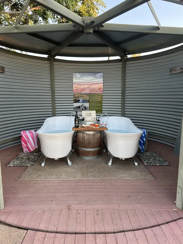Twin white clawfoot bathtubs filled with water under a covered pavilion at Julia Creek Artesian Baths near Julia Creek Queensland.