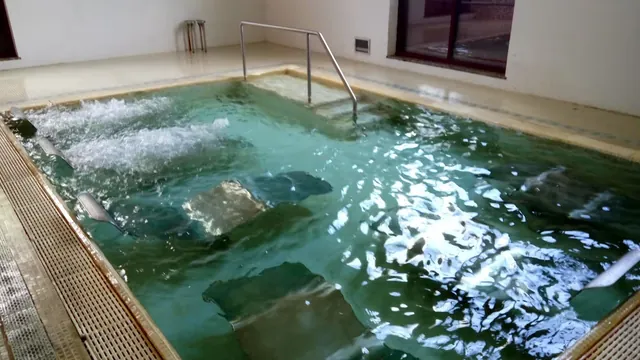 Spacious indoor mineral pool with bubbling water jets and stainless steel handrails at Termas de Moncao, located in Moncao Portugal.