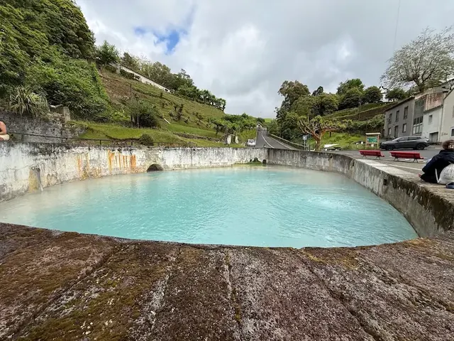 Outdoor turquoise thermal pools surrounded by lush hills at caldeiras da ribeira grande in portugal