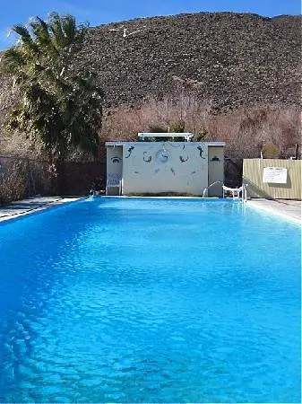 outdoor hot spring pool with desert hill in the background at shoshone hot springs california