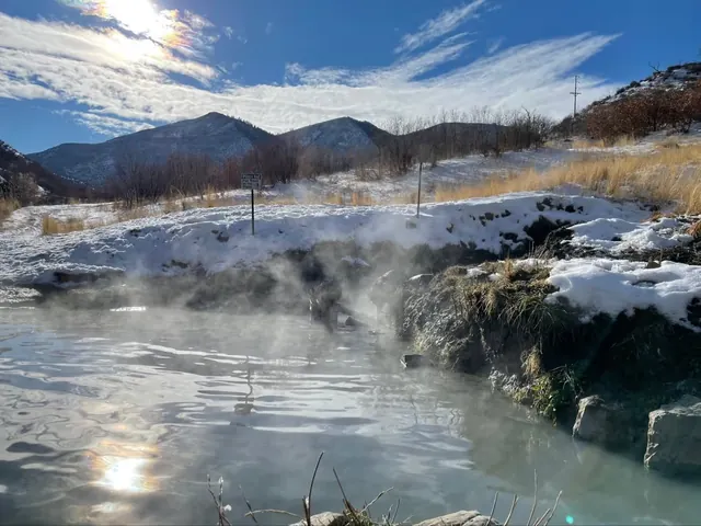 Steamy water in South Canyon Hot Springs pool surrounded by snowy banks and mountains near Glenwood Springs, Colorado, United States.