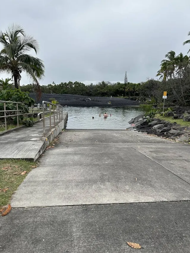 People soaking at outdoor hot spring pools in a lush vegetation setting at pohoiki warm ponds hawaii