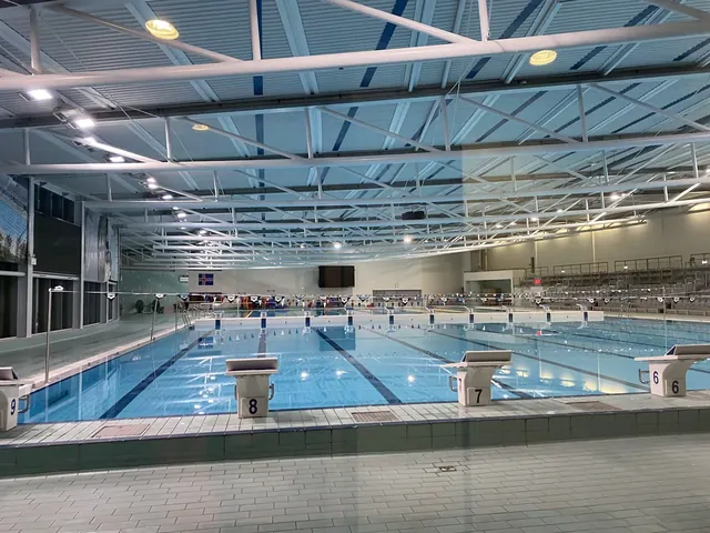 Indoor mineral pool area at Laugardalslaug with clear water, swimming lanes, and angled roof lights in Reykjavik Iceland.