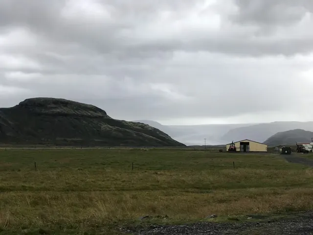 Several outdoor spa pools with people soaking under a cloudy sky near Hoffell Hot Tubs near Hofn in Iceland.