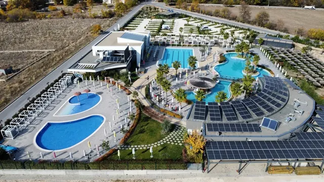 Aerial view of Terme di Hissar hot spring complex in Hisarya Bulgaria showing multiple outdoor pools with sun umbrellas and surrounding dry.