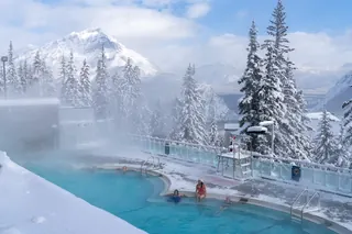 Banff Upper Hot Springs, Canada - outdoor mineral pool with steam rising, framed by Mount Rundle and the Canadian Rockies in winter snow